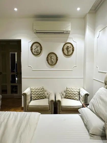 This bedroom corner in a Central Park resort residence features a classic and elegant seating area. I used neo-classical wall moulding to frame the space, where two comfortable armchairs create a perfect spot for reading or quiet conversation.