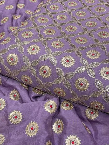 Displaying the rich lavender Chinon fabric, a popular choice for festive wear. The silver embroidery and red detailing stand out beautifully against the purple background.