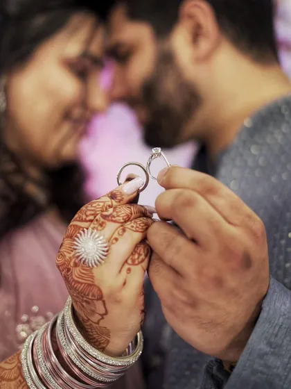 A close-up shot focusing on the engagement rings, a symbol of the couple's commitment. We pay close attention to these important details, capturing the intricate mehendi and the promise of a new beginning.