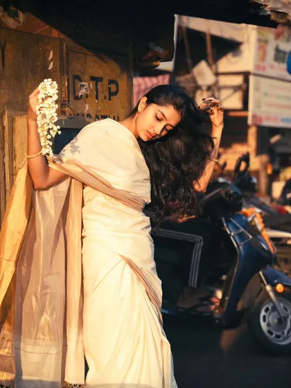 An unposed, natural moment on the street. The focus is on the movement of her hair and the soft, late afternoon sunlight.