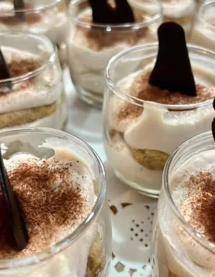 A close-up of my sophisticated Tiramisu, prepared in individual glass jars. This classic Italian dessert, with its layers of creamy mascarpone and coffee-soaked ladyfingers, is a perfect, elegant ending to any gourmet meal.