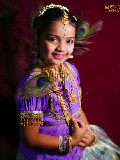 Another stunning portrait of the girl in traditional dress. The rich colors of her outfit and the deep red background create a very regal look.