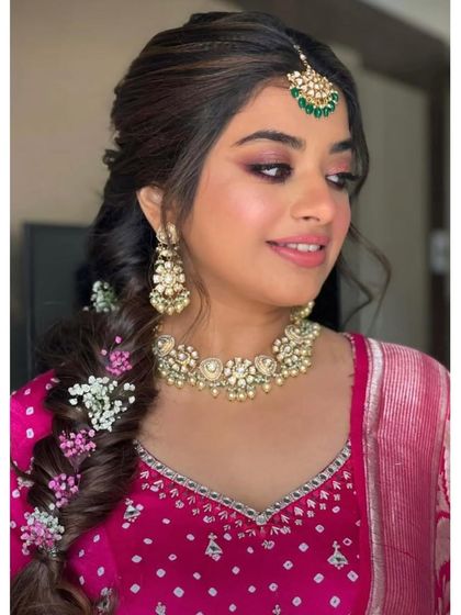 A beautiful party look with a braided hairstyle and soft, glowing makeup.