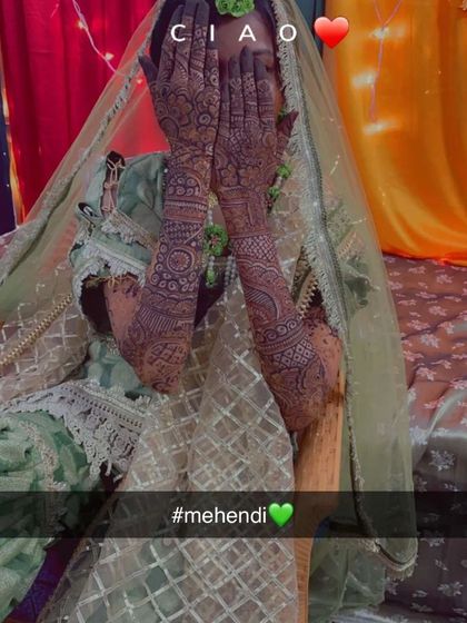 A candid shot of the bride in her beautiful green outfit, her hands covered in my intricate henna work with a lovely dark stain.