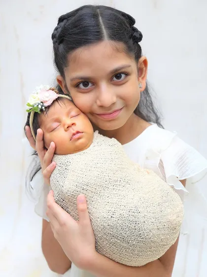 There is nothing more precious than the bond between siblings. Here, a proud big sister holds her newborn sibling, a quiet, tender moment captured forever in my Mumbai studio.