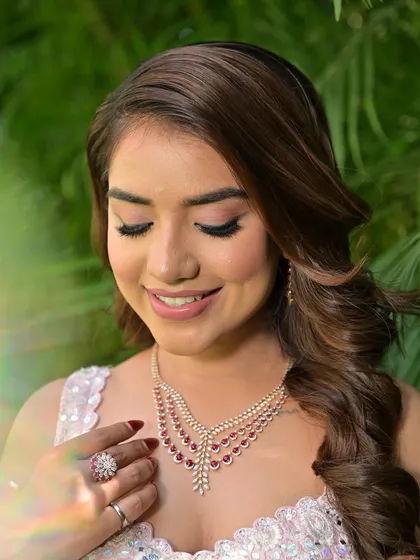 A close-up of the soft, shimmery eye makeup and the beautiful ruby necklace. The look is balanced and harmonious.