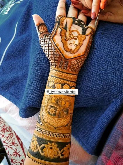 A full-arm design featuring a semi-realistic bridal portrait on the palm. Below the portrait, you can see other traditional motifs like an elephant, blending storytelling with classic patterns.
