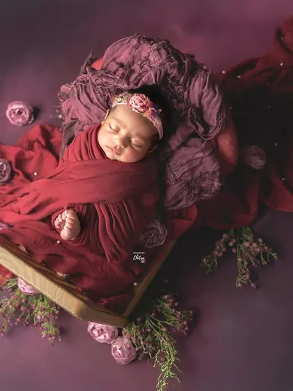 A portrait of peaceful slumber, wrapped in rich plum and deep red tones. My styled studio sessions use beautiful colour palettes and soft textures to create artistic, memorable images of your baby.