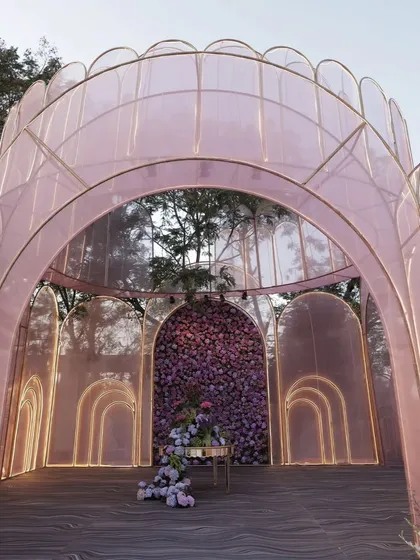 A whimsical and modern entrance structure. The series of pink, translucent arches, lit from within, creates a futuristic yet romantic gateway, showcasing my ability to work with unconventional materials and designs.