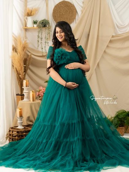 This shot captures the rich color and texture of the green gown, highlighting the mother's serene expression.