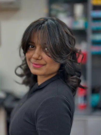 A happy client with her new copper highlights and curtain bangs. This style is chic, modern, and frames her face beautifully.