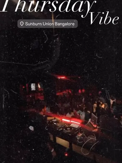A grainy, atmospheric shot capturing the Thursday vibe at Sunburn Union Bangalore. The focus is on the music and the energy of the packed room.