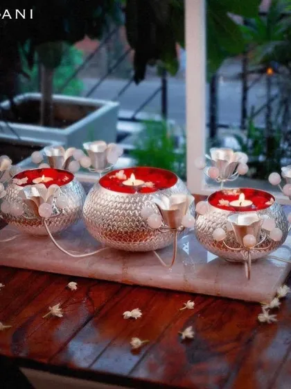 Where luxury meets functionality. This stunning centerpiece features three silver-plated bowls on a marble tray, surrounded by rose quartz-accented candle holders, creating a magnificent display of light and elegance.
