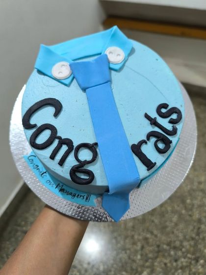 A sharp-looking promotion cake to congratulate new managers. This simple design features a fondant shirt collar and tie on a light blue buttercream base.