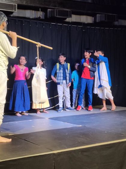 An energetic scene from the children's play, full of movement and expression. The students learn to use the entire stage and interact dynamically with each other.