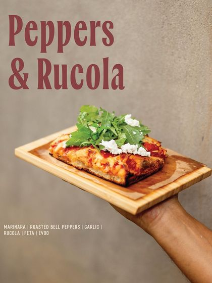 Our Peppers & Rucola slice, a fresh and vibrant option with roasted bell peppers, garlic, feta, and fresh arugula.