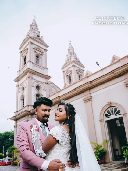 An elegant portrait of a Christian bride and groom outside a beautiful church. This image captures a classic, romantic moment from their wedding day.
