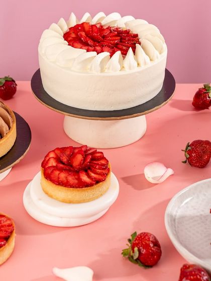 A full view of our strawberry dessert collection, including the Strawberry Vanilla Cake, Strawberry Chocolate Tart, and individual tartlets.
