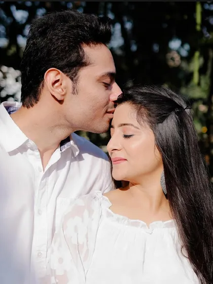 A sun-kissed, happy moment. The makeup is minimal and glowing, perfect for a casual, outdoor shoot.