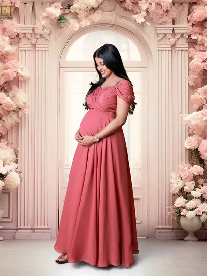 An example of our fairytale studio setups. The mom-to-be stands in an elegant pink gown before a grand floral archway, creating a timeless and romantic pregnancy portrait.