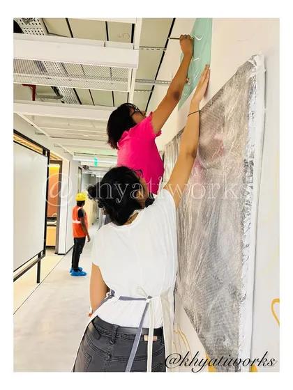 Teamwork makes the dream work. Here, we are carefully installing a large canvas piece as part of a larger office art project.