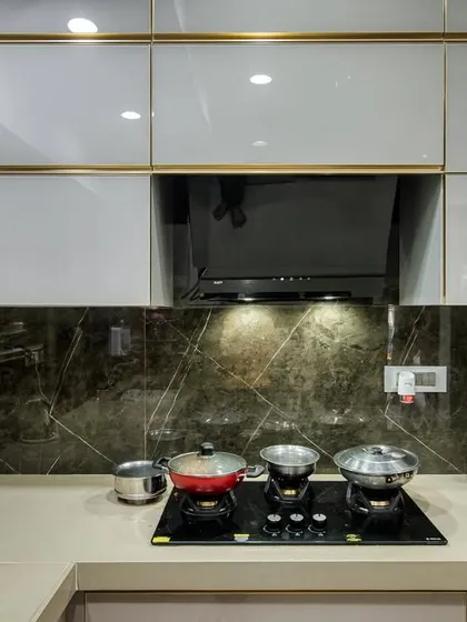 A close-up of the cooking area in the C-shaped kitchen, with a modern hob and chimney.