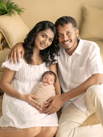 A happy family of three, welcoming their newborn baby. The smiles on their faces say it all.