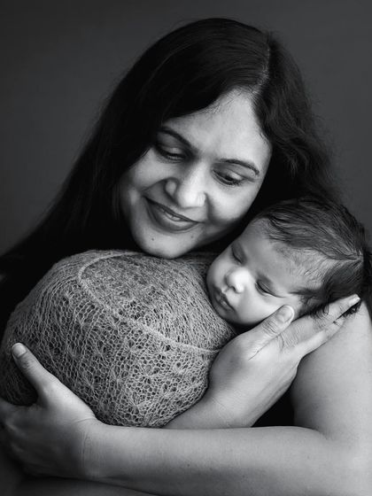 The bond between a mother and her newborn is just magical. This classic black and white portrait captures that gentle embrace and overwhelming love.