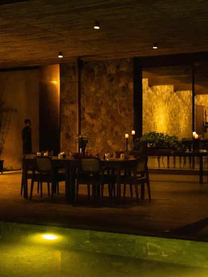 A long table set for a special celebration by the pool at night, creating a magical ambiance.