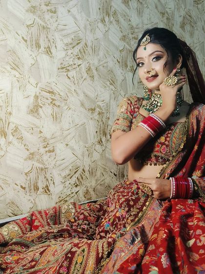 Another beautiful angle of this maroon bridal look, highlighting the contrast with the green jewellery.