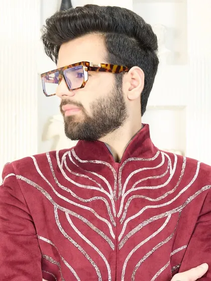 This crimson velvet jacket with intricate silver embroidery is a masterpiece of festive elegance, perfect for the man who owns every occasion.