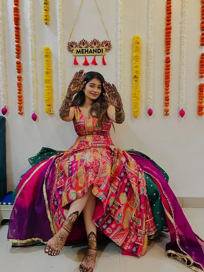 A full-length shot of Shrutika, showing her beautiful mehendi on both her hands and feet. She looks like a princess.