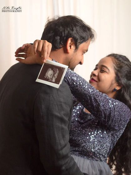 The beginning of a new chapter. This creative maternity shot features the couple sharing a loving gaze while holding their baby's first sonogram picture.