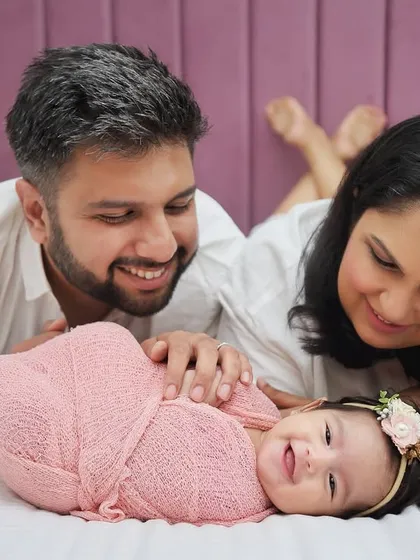A candid moment of pure joy as new parents gaze at their smiling newborn. These relaxed, in-the-moment shots often become the most cherished memories.