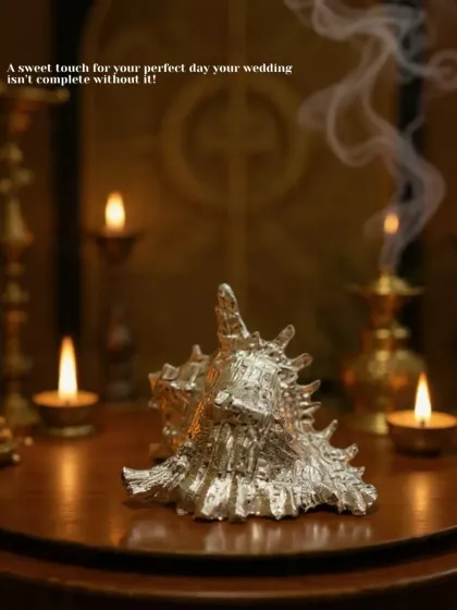 A sweet touch for your perfect day. This gold-plated original shell, set against a backdrop of diyas, adds a touch of divine elegance to your wedding pooja setup.