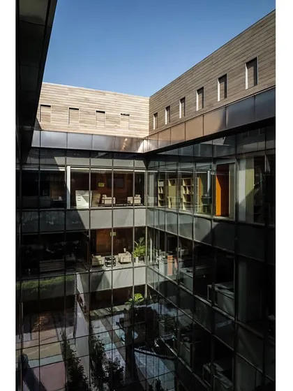 A view from above into the multi-story internal courtyard of the Stainless Steel Office, showing how different floors connect visually through the central void.
