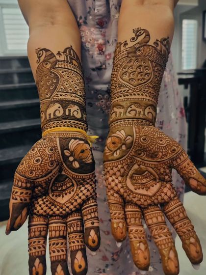 A beautiful and detailed mehendi for the bride's mother. This design is packed with traditional elements like peacocks, elephants, and architectural dome patterns, creating a rich and celebratory look.