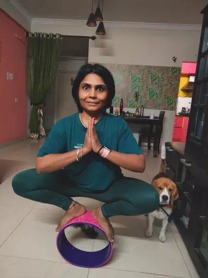 Finding balance is a constant practice, both on and off the mat. Here I am working on my stability in Malasana (Garland Pose) on a yoga wheel, with a fun visit from my practice partner, my dog. It’s a playful reminder not to take things too seriously.