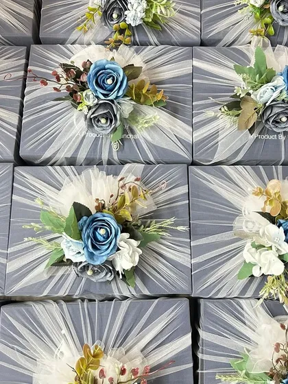 Beautifully wrapped gift hampers for a corporate client, ASTCL, featuring a dusty blue theme with delicate tulle and floral toppers.