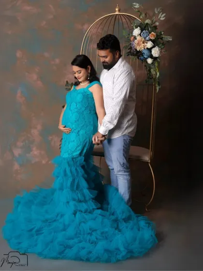A classic and tender pose, with the partner standing behind and gently holding the baby bump. The love and support are beautifully evident.