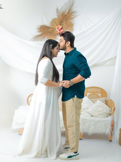 A sweet and intimate pose where the partner kisses his wife's forehead. Her eyes are closed in blissful contentment, capturing the love and security of their relationship.