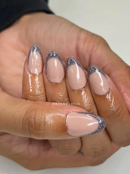 A close-up of the reflective silver French tips. The glitter catches the light beautifully, making your nails sparkle with every movement.