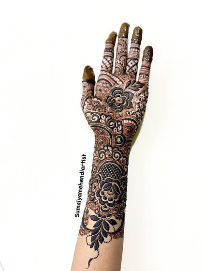 A mini bridal henna with a beautiful floral theme. The design flows from the wrist down to the fingers, with a large flower on the back of the hand.