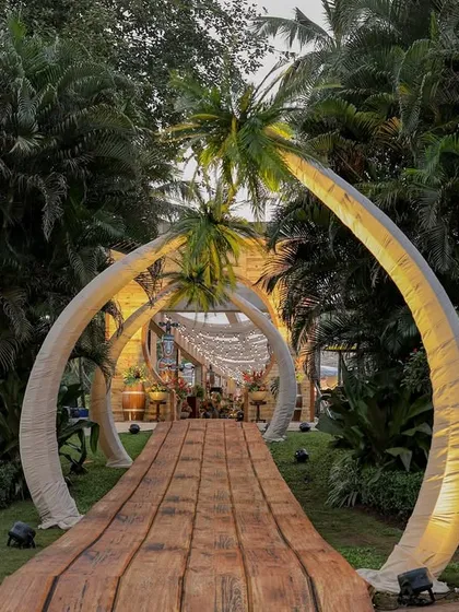 For a truly immersive escape, I designed this Bora Bora themed entrance. Guests journey through illuminated palm arches and along a rustic wooden pathway, immediately transported to a tropical paradise where every detail whispers of exotic elegance and celebration.