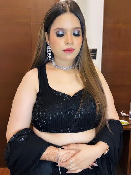 A close-up with eyes closed, showing the dramatic silver and black eye makeup.