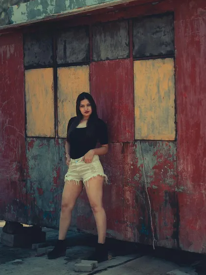 I was drawn to the colors and textures of this old, peeling wall. It created a rustic, almost painted backdrop for this simple but strong portrait.