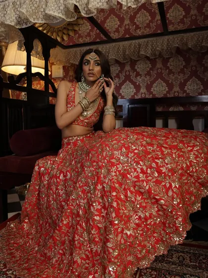 Seated gracefully, the bride looks radiant. This pose allows a closer look at the detailed work on the lehenga skirt and the stunning jewellery.