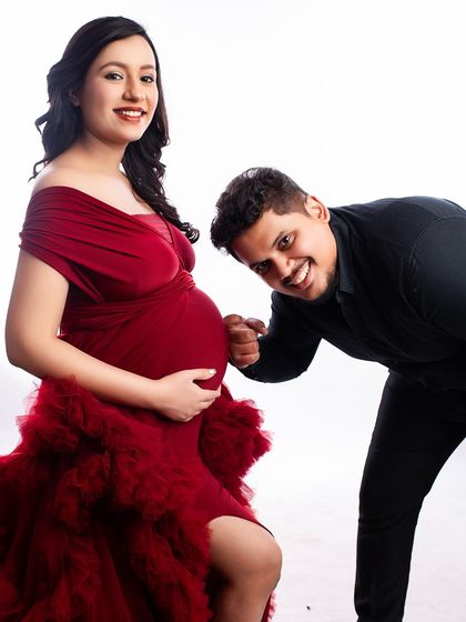 A playful and fun moment with the dad-to-be fist-bumping the baby bump. This is a great way to capture the joyful and lighthearted side of a couple's pregnancy journey.