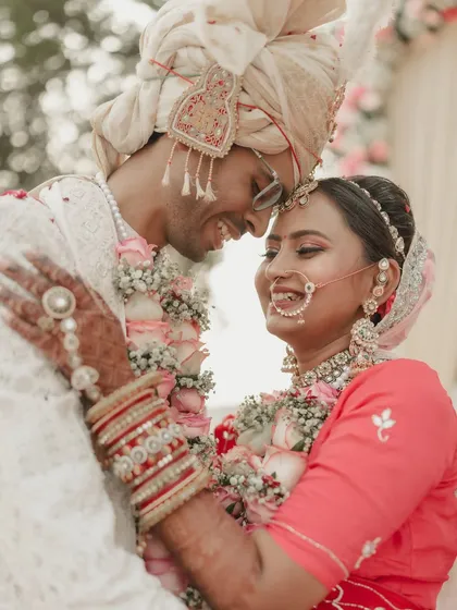 A warm embrace after the varmala exchange. This photo captures the pure happiness and relief of the couple, wrapped in garlands and love, marking the beginning of their life together.