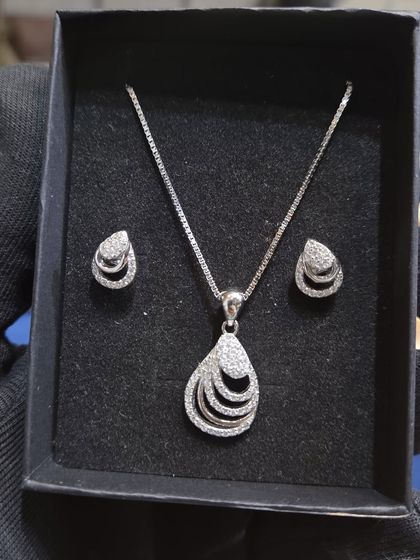 This silver 925 pendant set features a modern, layered teardrop design. It's a stylish and unique gift for any occasion.